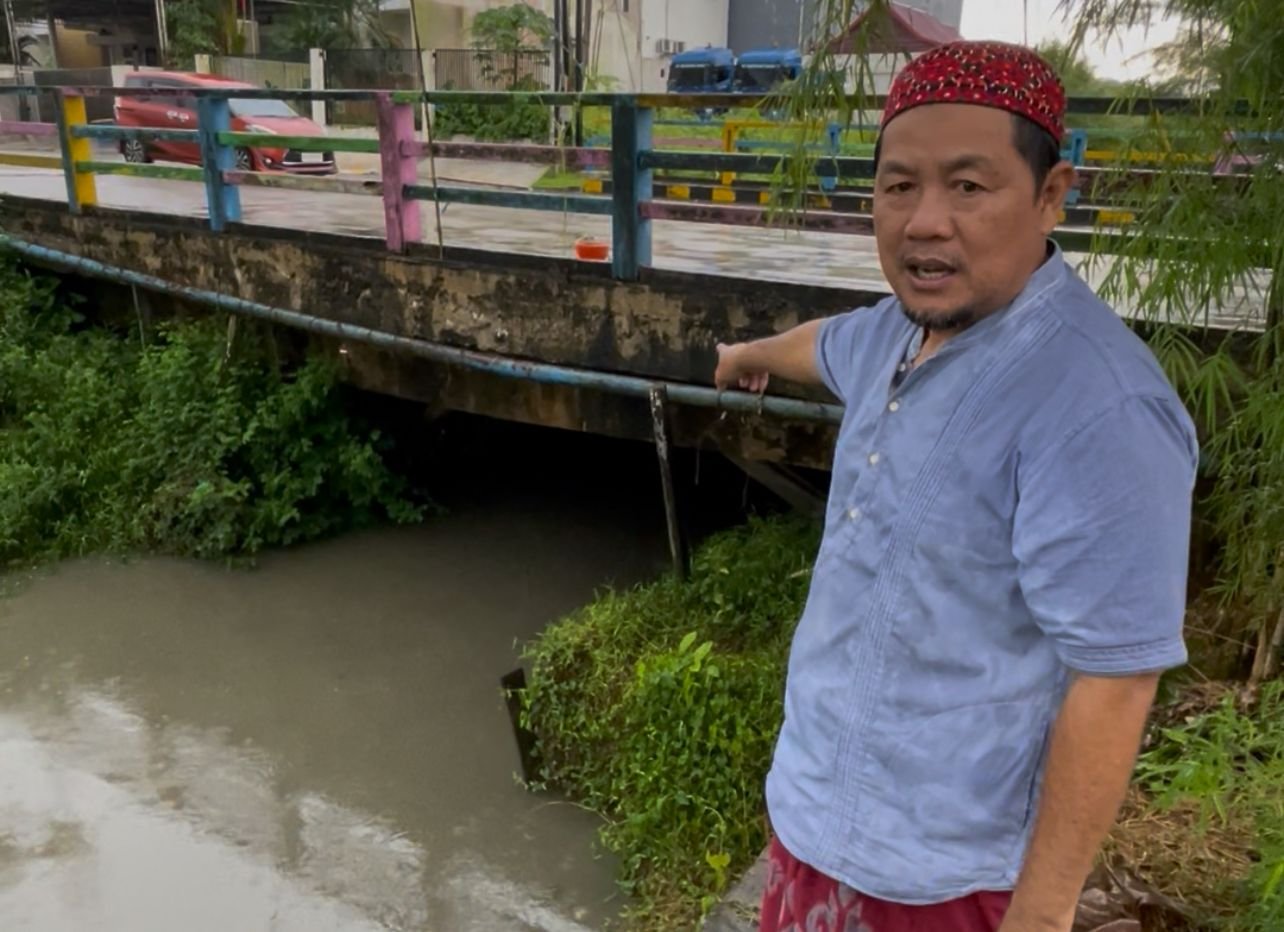 Ketua RT 30 Sempaja Selatan menunjukkan titik aliran anak Sungai Perjuangan yang kerap dipenuhi sampah plastik dari kawasan GOR Kadrie Oening, terutama usai hujan dan air pasang